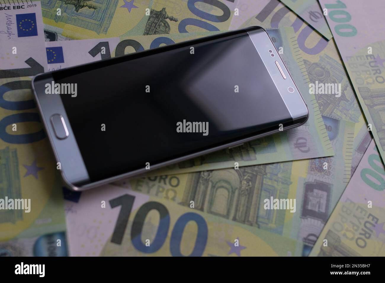 smartphone lies on 100 euro banknotes Stock Photo