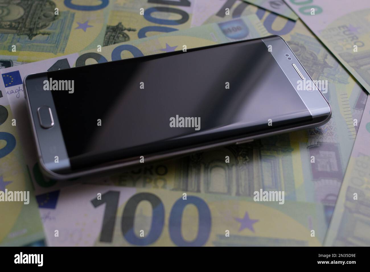 smartphone lies on 100 euro banknotes Stock Photo