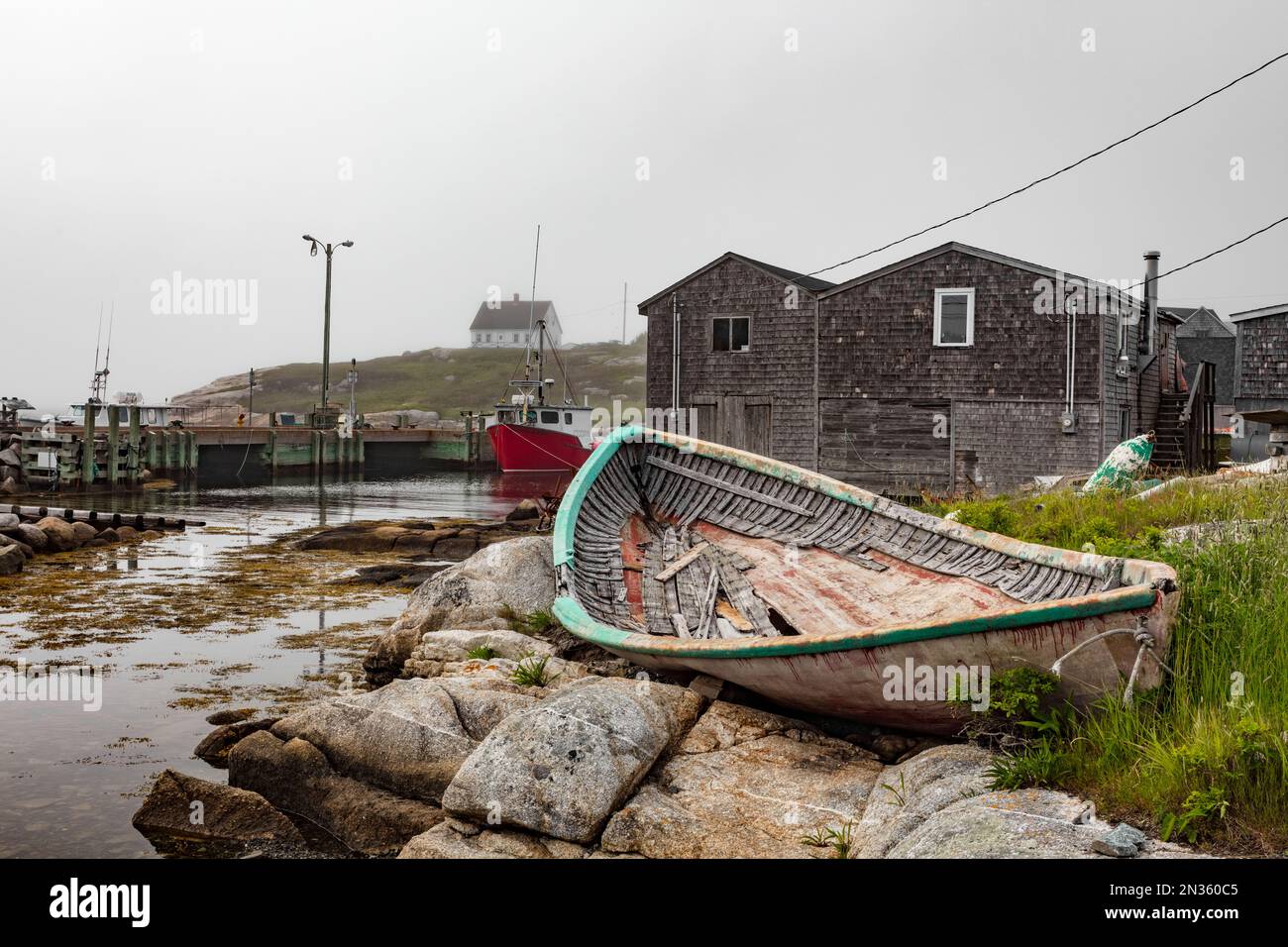 Fog rolls in over the iconic Peggy's Cove village, adding a grainy look to everything. Stock Photo