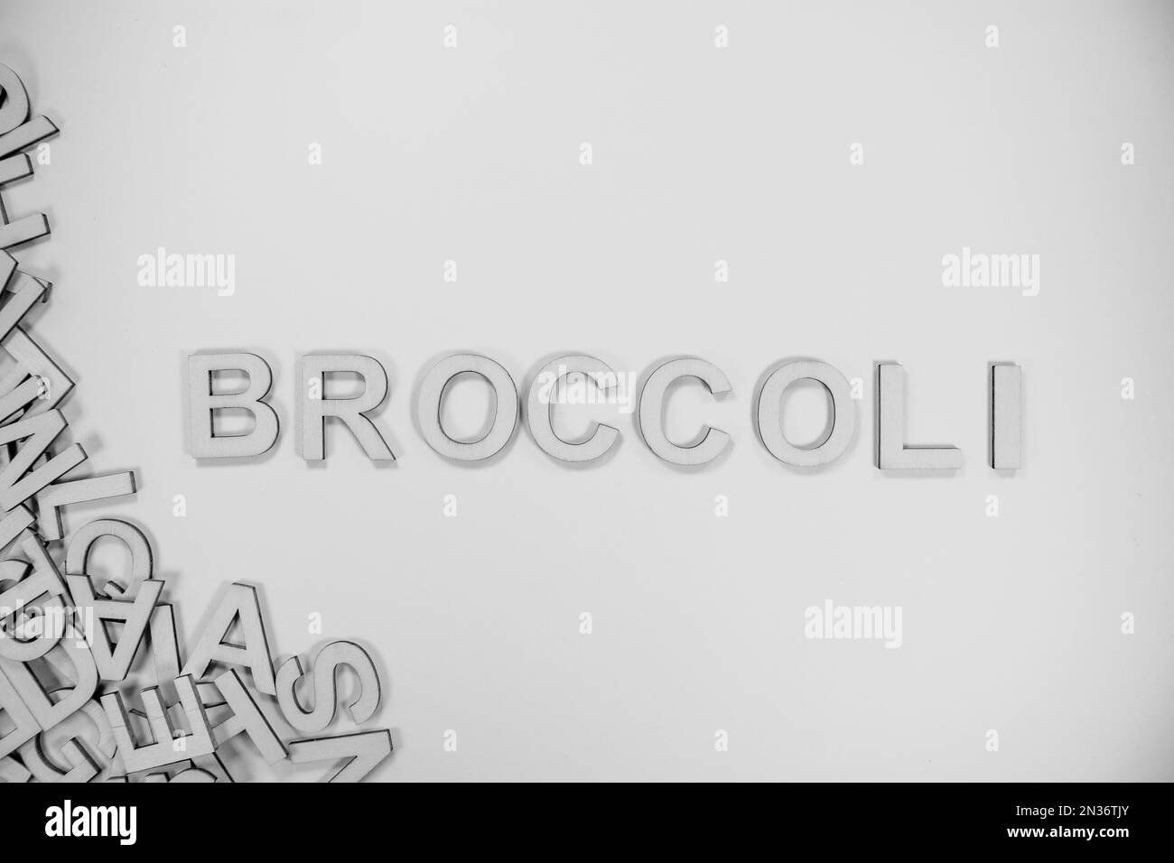 BROCCOLI in wooden English words language capital letters spilling from a pile of letters in black and white Stock Photo