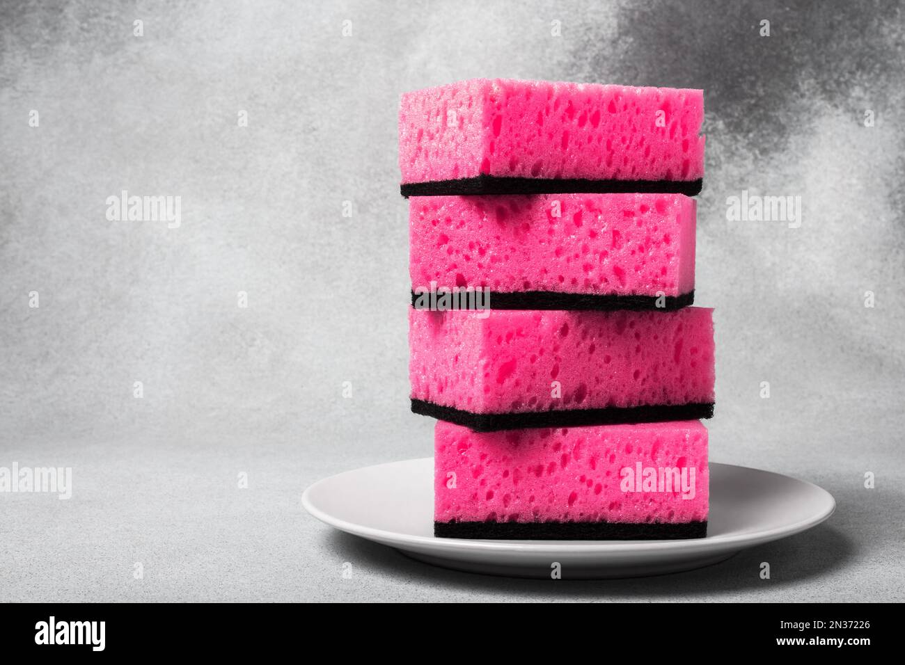 https://c8.alamy.com/comp/2N37226/a-stack-of-barbie-pink-dishwashing-sponges-on-a-white-plate-close-up-on-a-neutral-gray-background-gentle-dishwashing-house-cleaning-2N37226.jpg