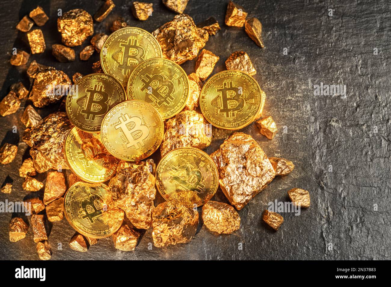 Bitcoins and pieces of gold closeup. Bitcoin against gold, what is the more attractive asset? Stock Photo