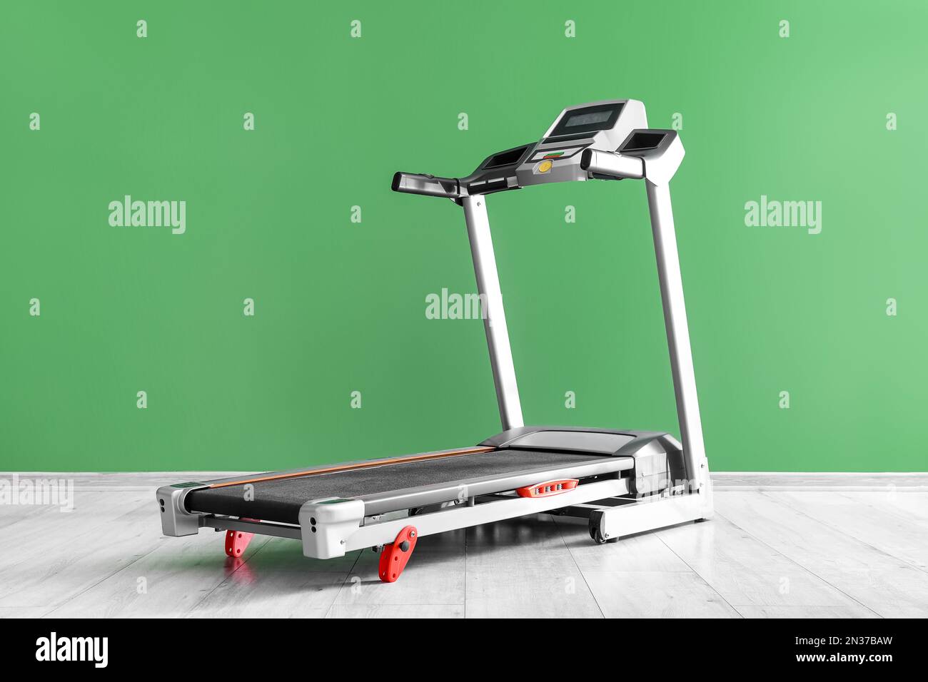 Modern treadmill near green wall Stock Photo - Alamy
