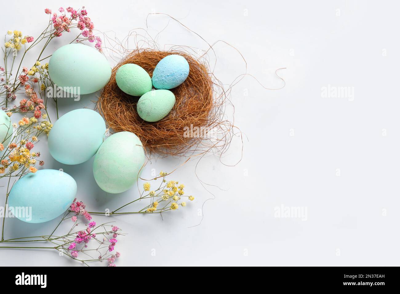 Composition with painted Easter eggs and gypsophila flowers on white ...