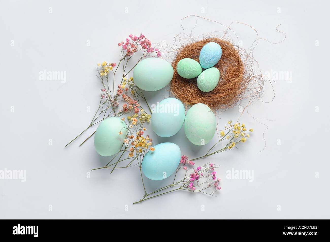 Composition with painted Easter eggs and gypsophila flowers on white ...