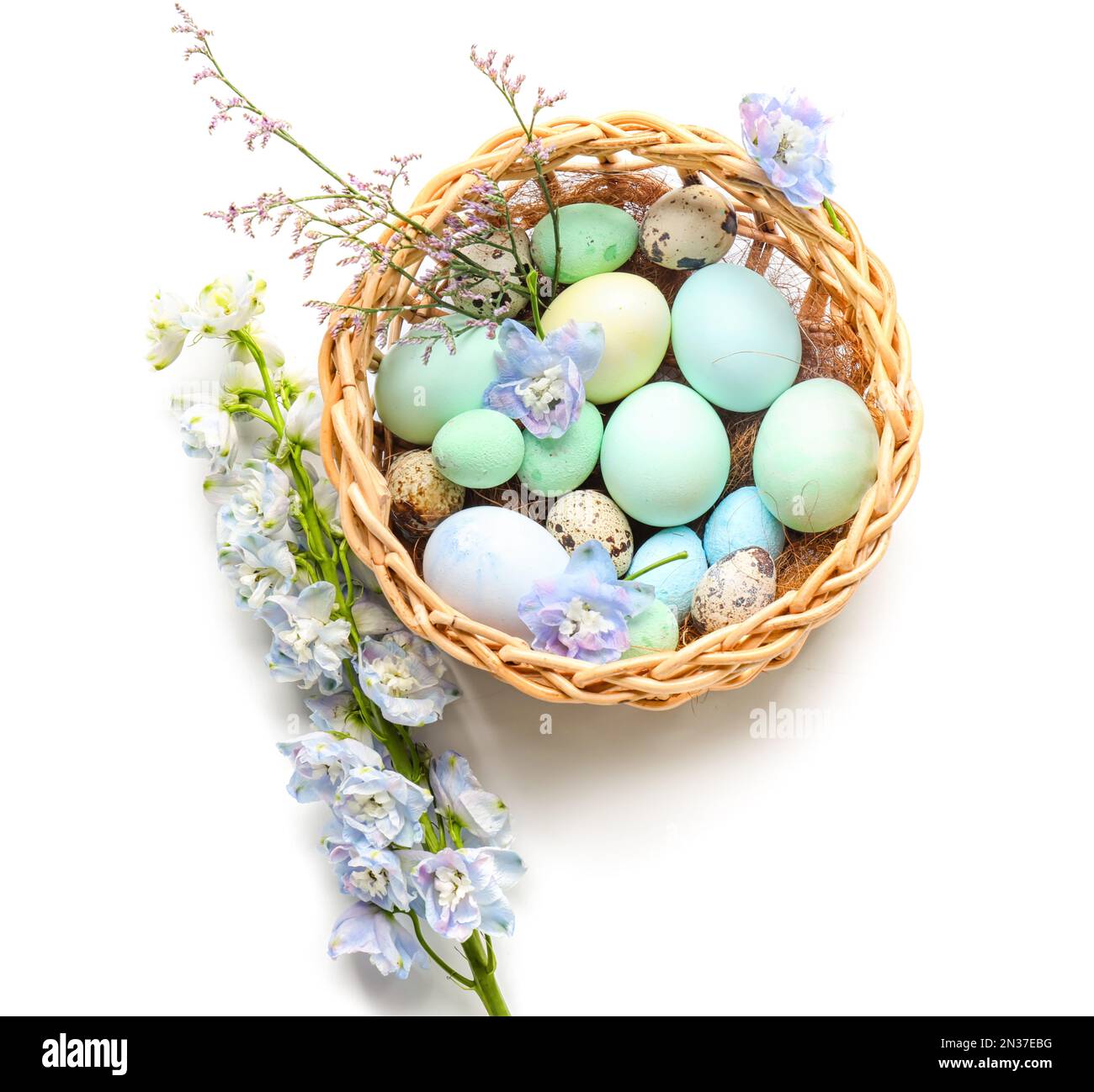 Basket with beautiful Easter eggs and flowers on white background Stock ...
