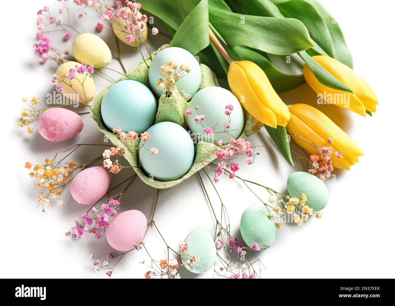 Composition with painted Easter eggs and flowers on white background ...