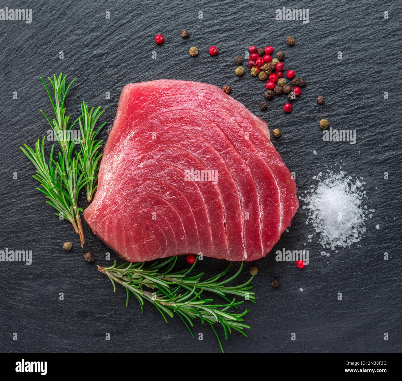 Raw tuna fish steak on natural stone black slate serving plate. Top