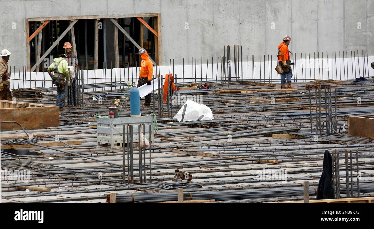 Workmen tie up rebar as construction continues on the interior and