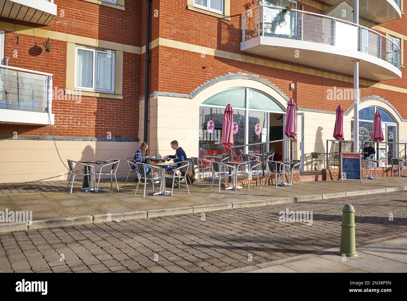 People outside a waterfront cafe at Ipswich Marina Stock Photo