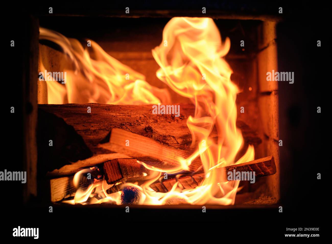 Wood on fire and live coals inside a woodburning fireplace Stock Photo