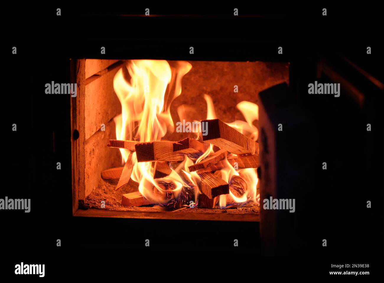 Wood on fire and live coals inside a woodburning fireplace Stock Photo