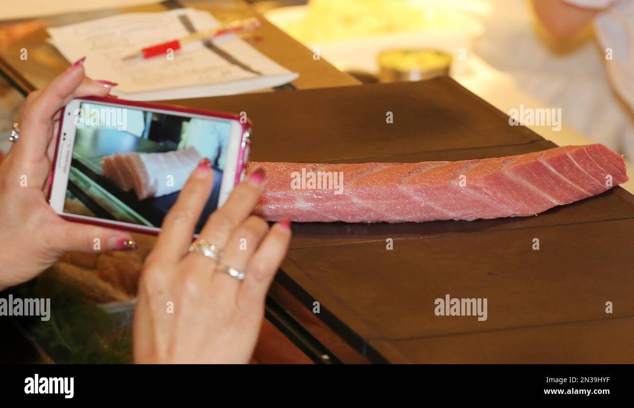 A customer of Sushi Zanmai restaurant takes a picture of fillet of