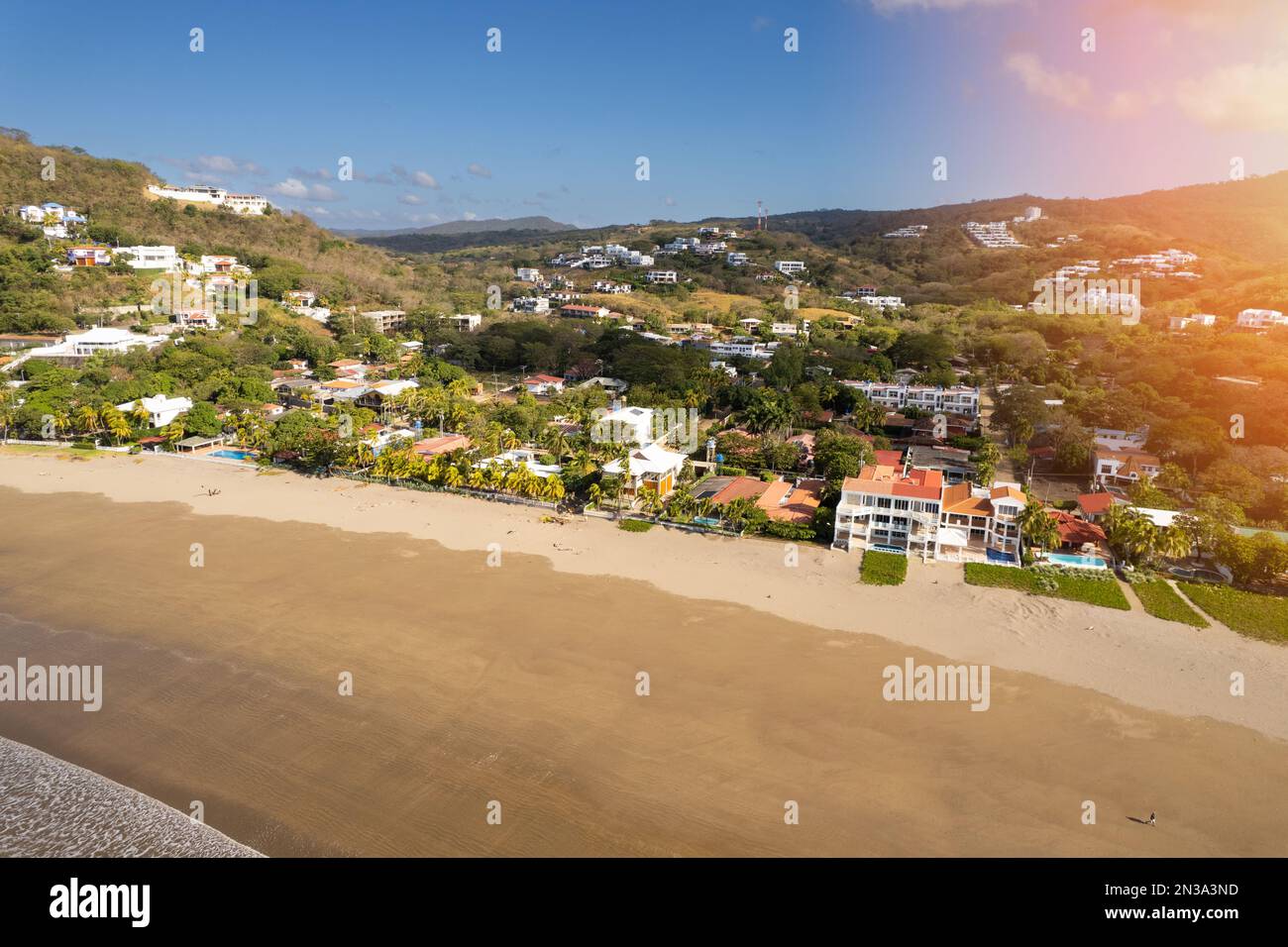 Residential building in green tropical background next to beach aerial drone view Stock Photo