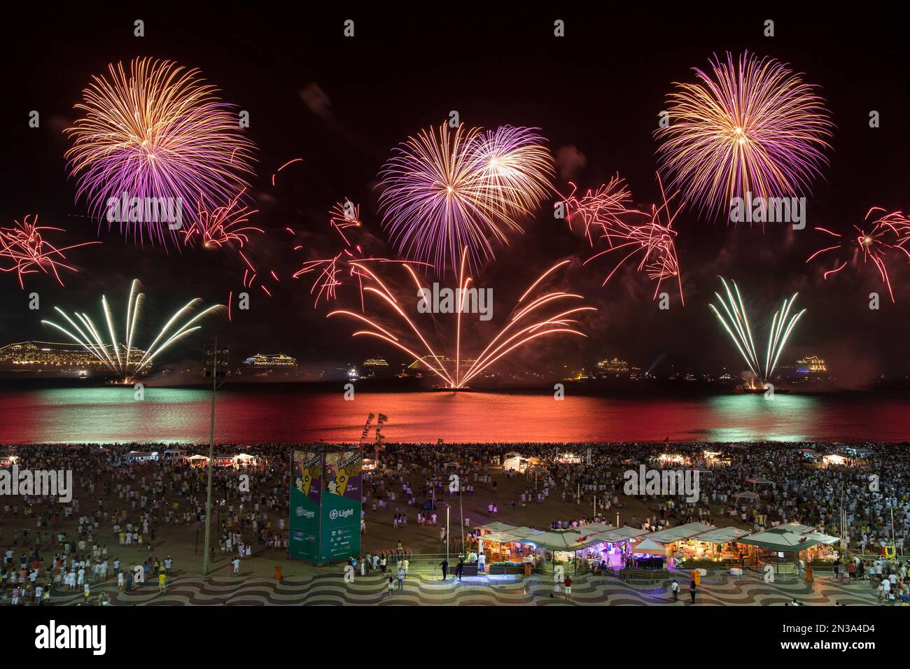 People watch fireworks exploding over Copacabana beach during New Year