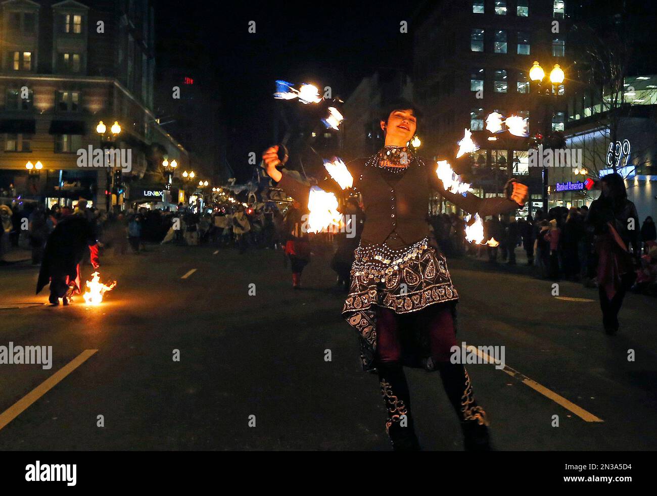 A fire dancer makes her way down Boylston Street in the First Night