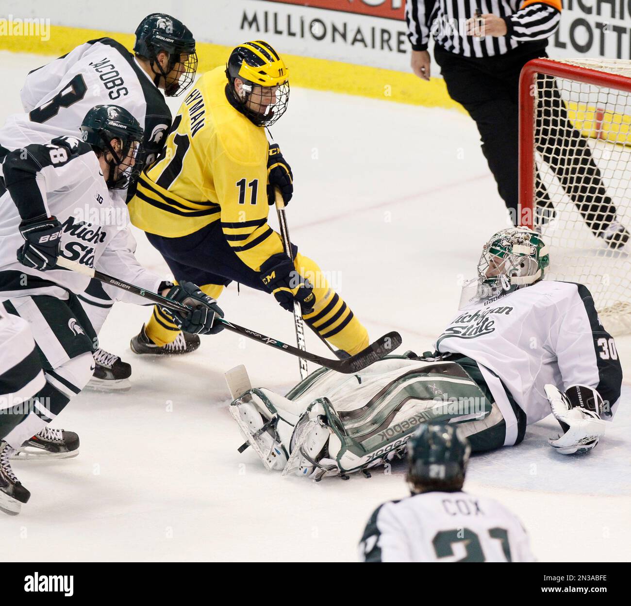 Michigan State goalie Jake Hildebrand (30) stops a shot by Michigan's