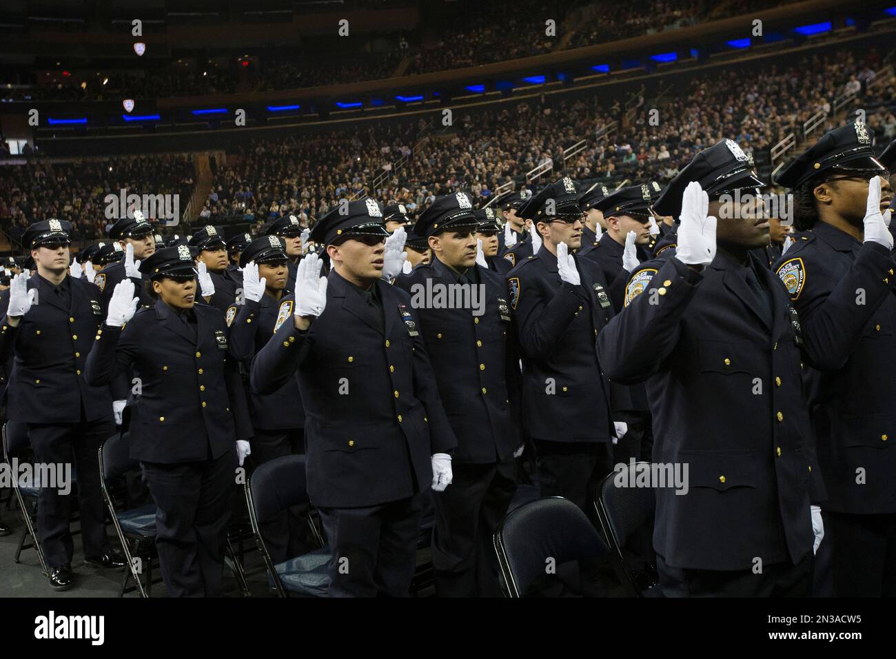 New recruits are sworn in during a New York Police Academy graduation ...