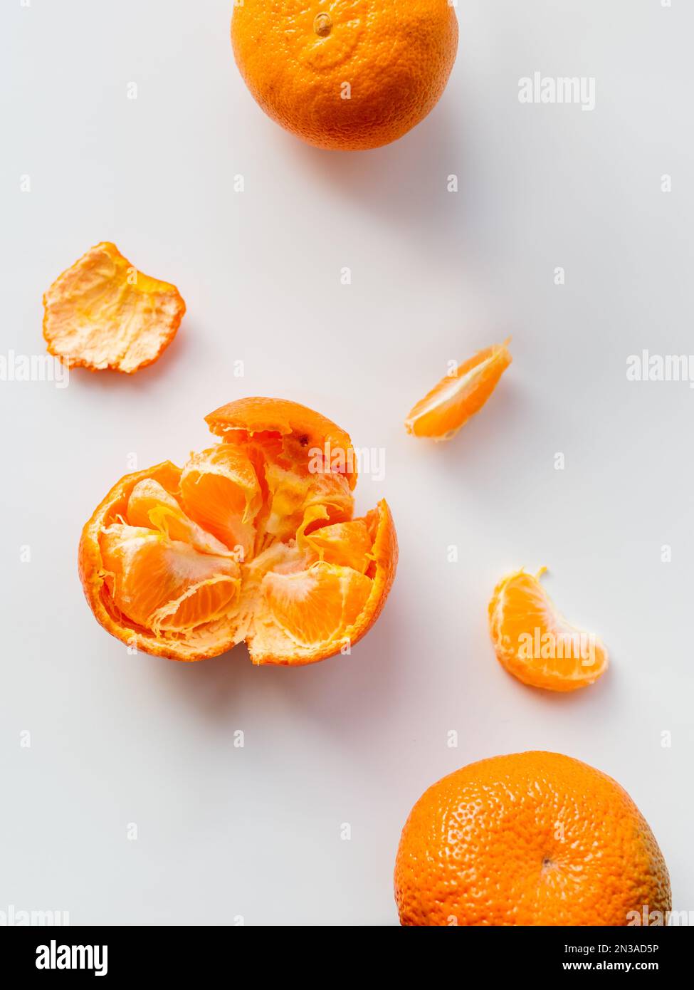 Top view of peeled and whole tangerine. Peel and pieces of citrus on ...