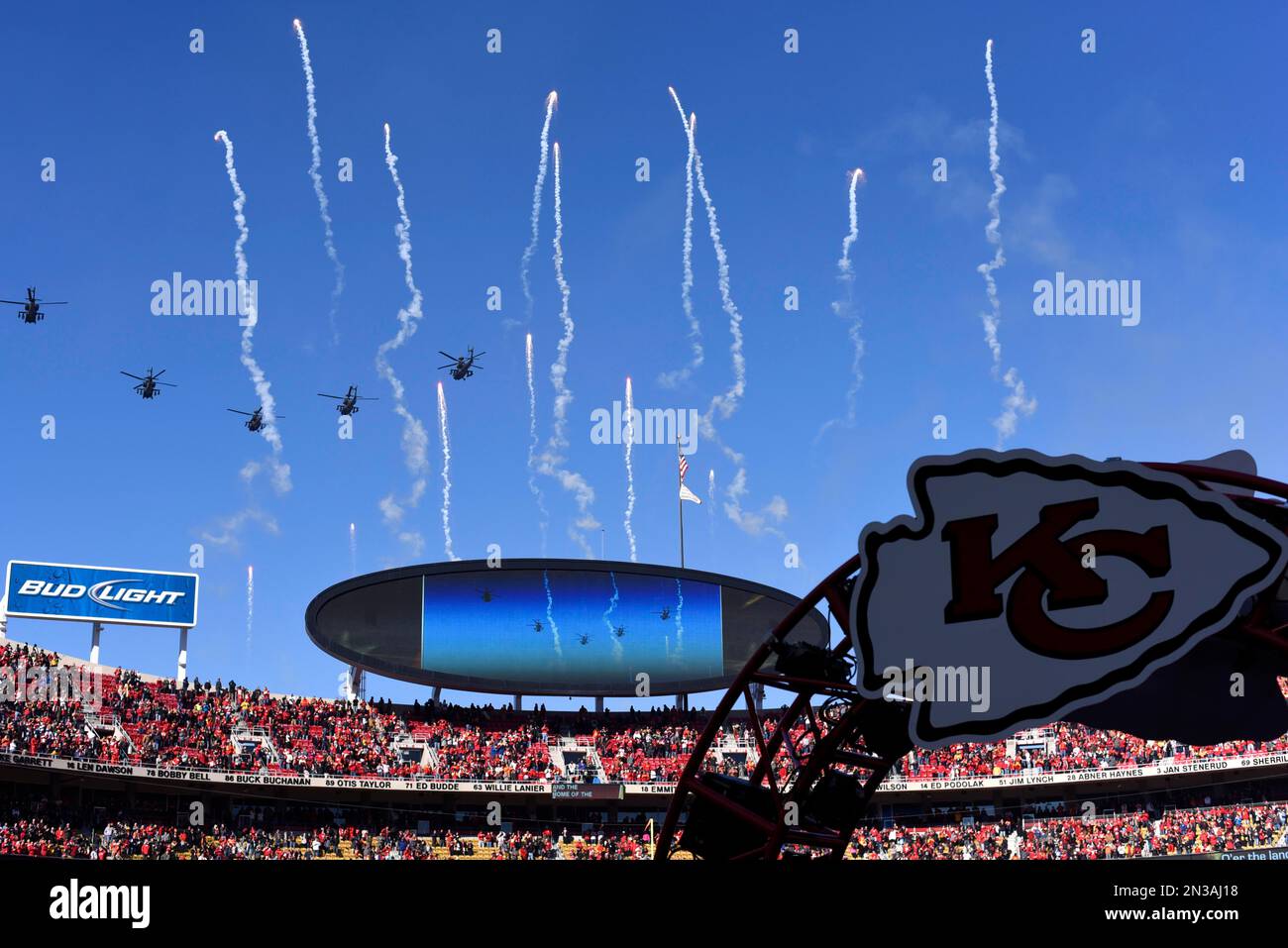 Apache helicopters fly overhead an NFL football game between the Kansas