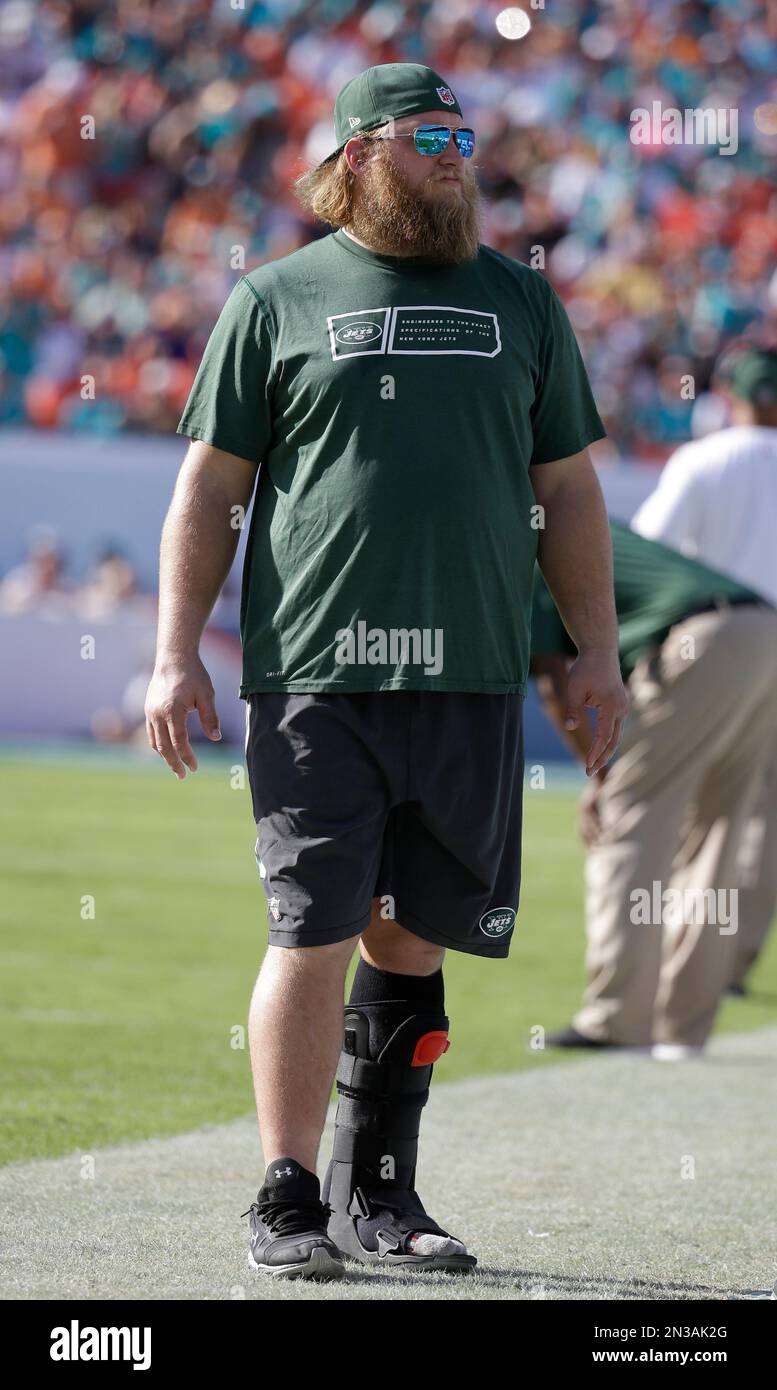 New York Jets center Nick Mangold walks the sidelines with a cast ...