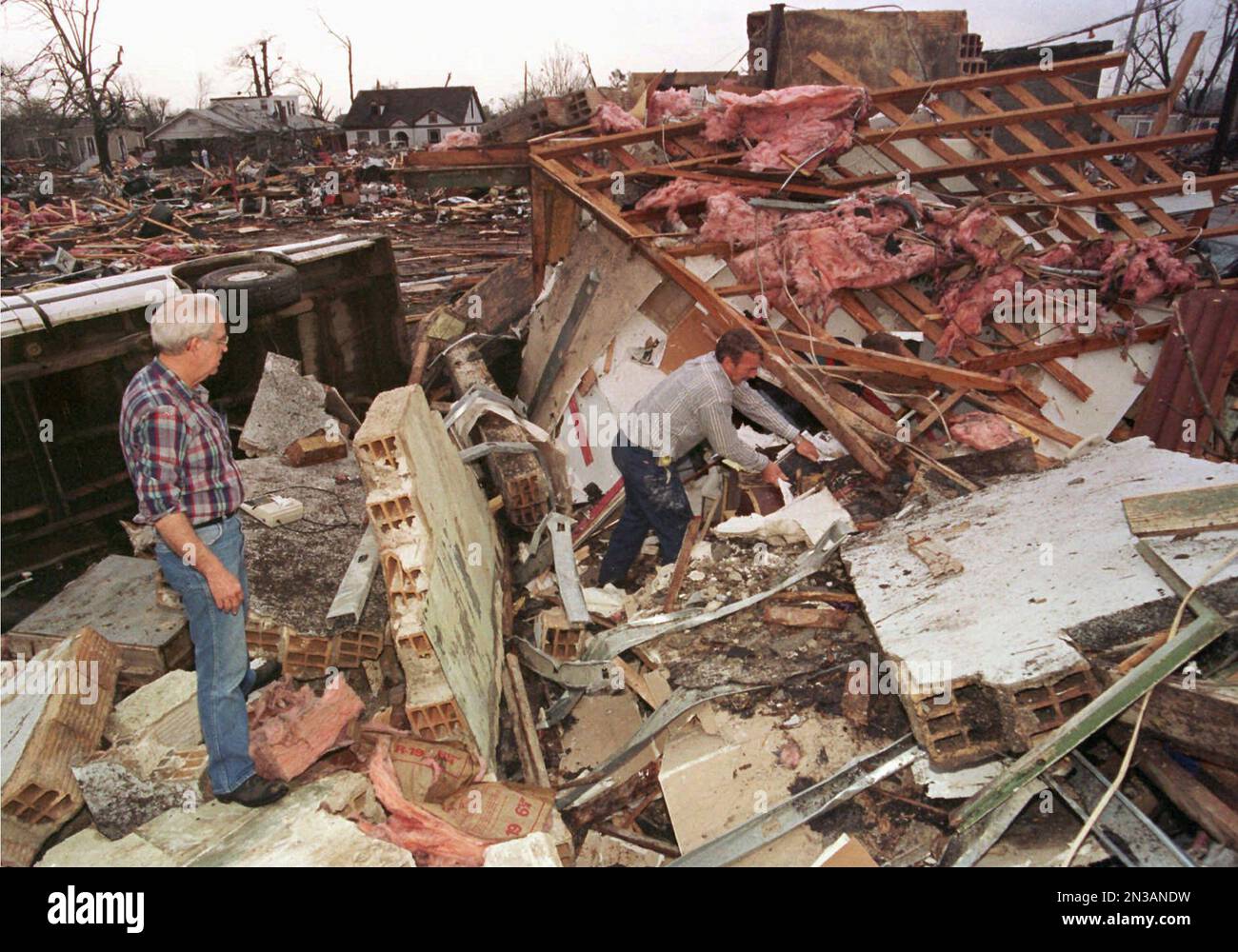 FILE - In this file photo taken March 1, 1997, Don Austin, left, stands by  what remains of an Arkadelphia, Ark., office building where a woman was  killed when a tornado struck