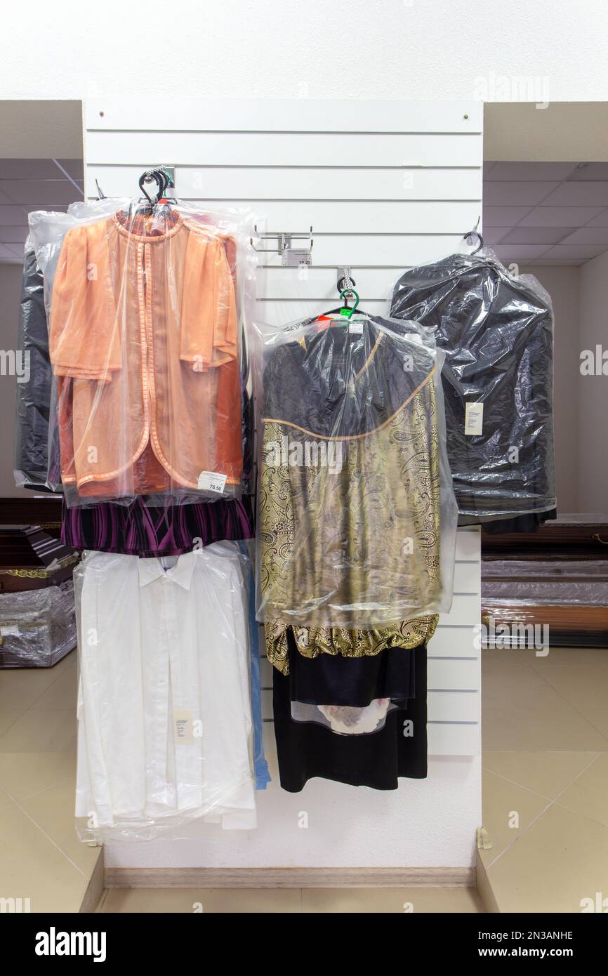 Hangers with men suits and women clothes for the deceased in a funeral