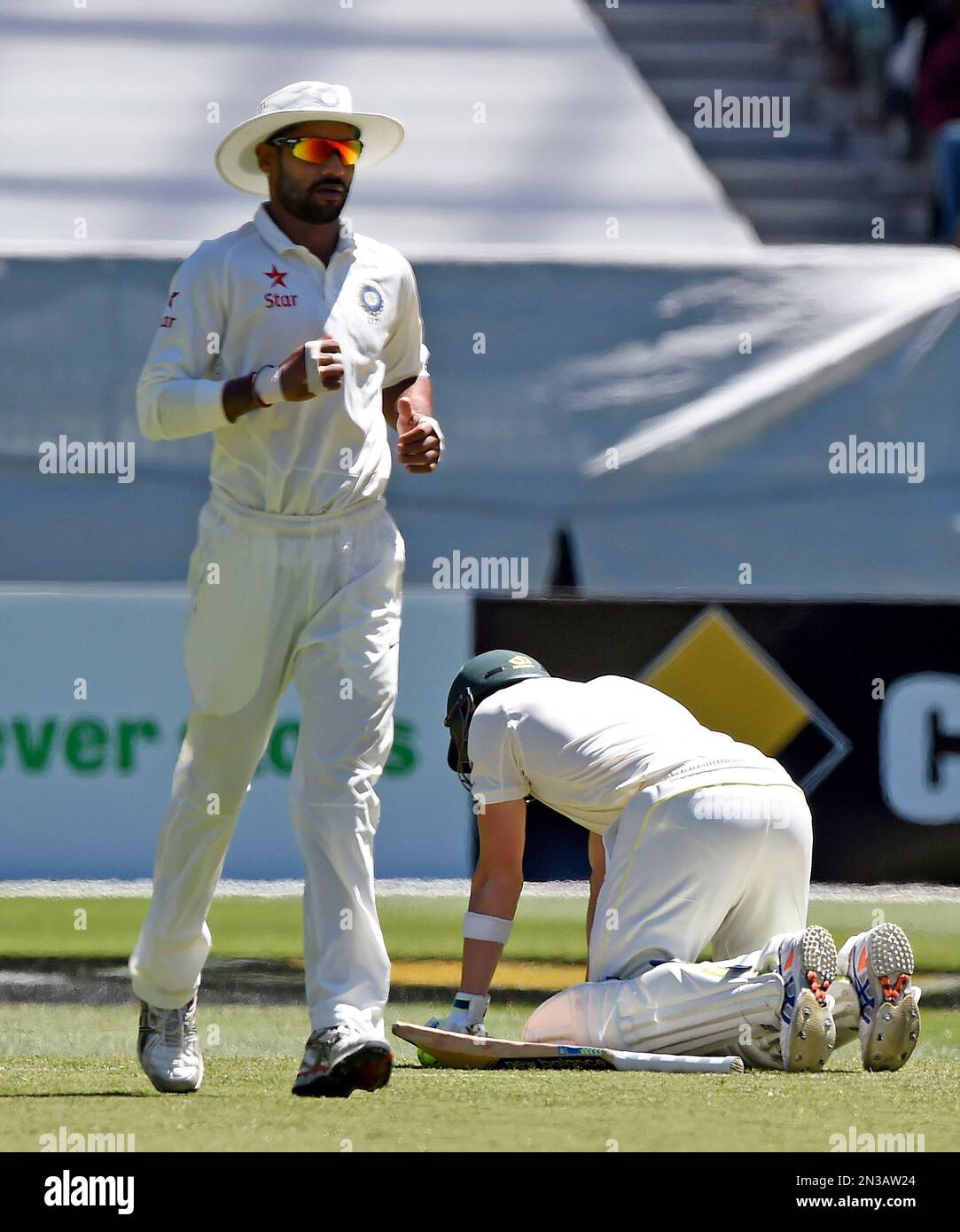 India's Shikhar Dhawan, left, runs past Australia's injured batsman Steve Smith during play on