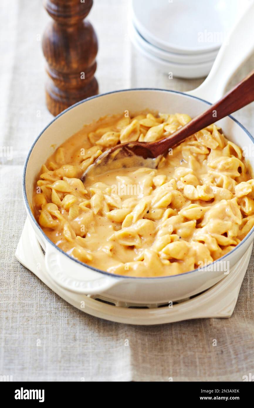 Shell pasta in a cheese sauce in white pot Stock Photo