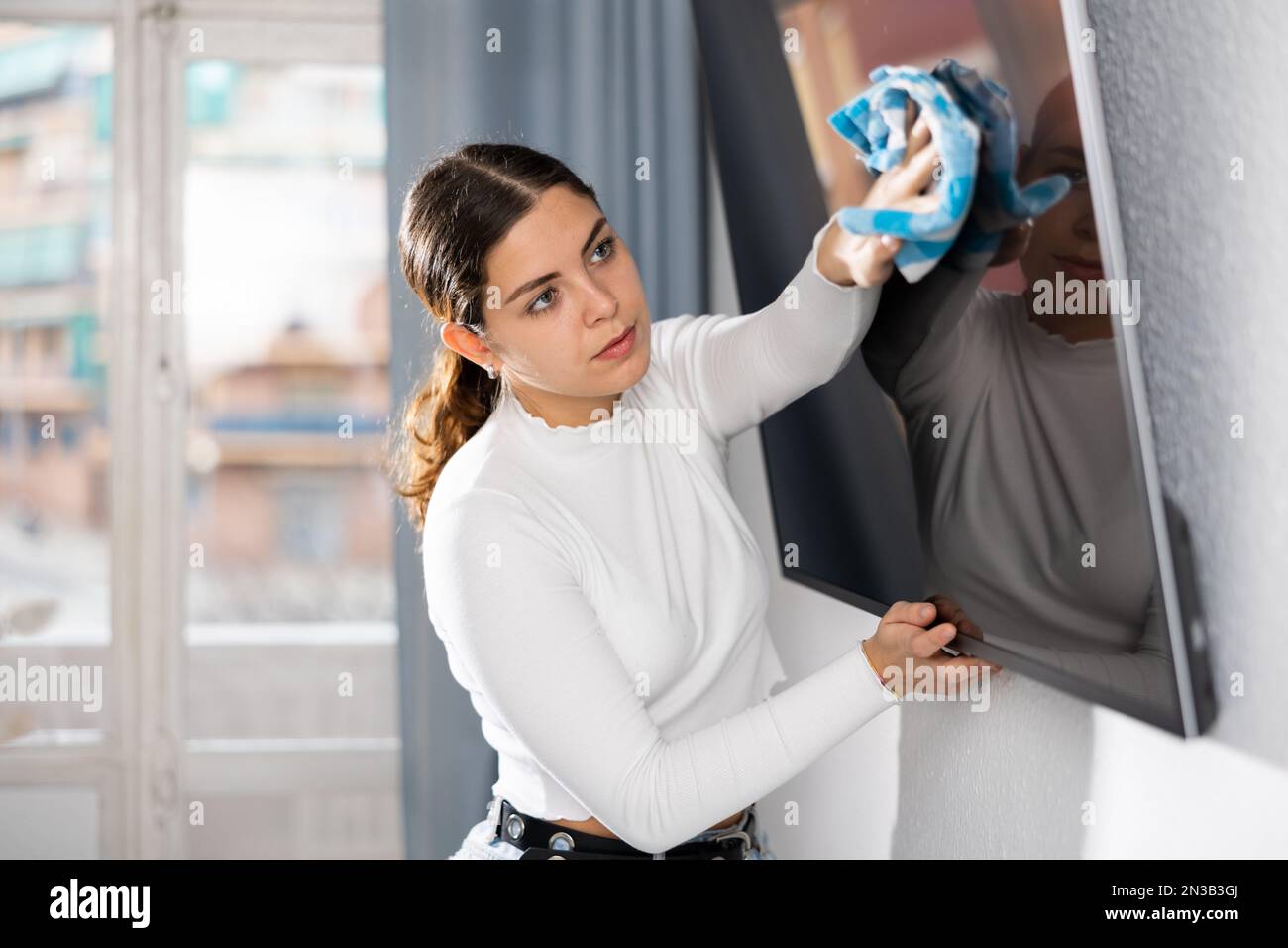 Tv Commercial Rag Young woman householder using rag to wash TV display Stock Photo - Alamy