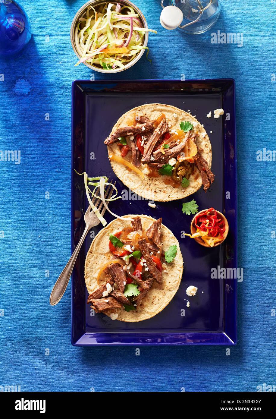 Beef Tacos on a blue platter with a side dish of coleslaw Stock Photo