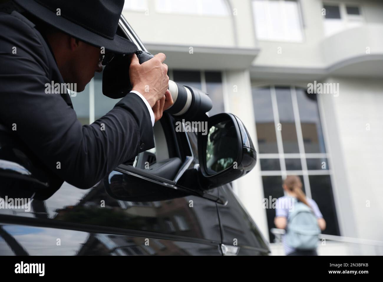 Private detective with camera spying from car Stock Photo