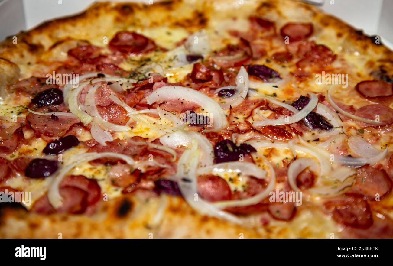 Traditional Brazilian pepperoni pizza with onions and black olives in selective focus. "calabresa pizza" Stock Photo