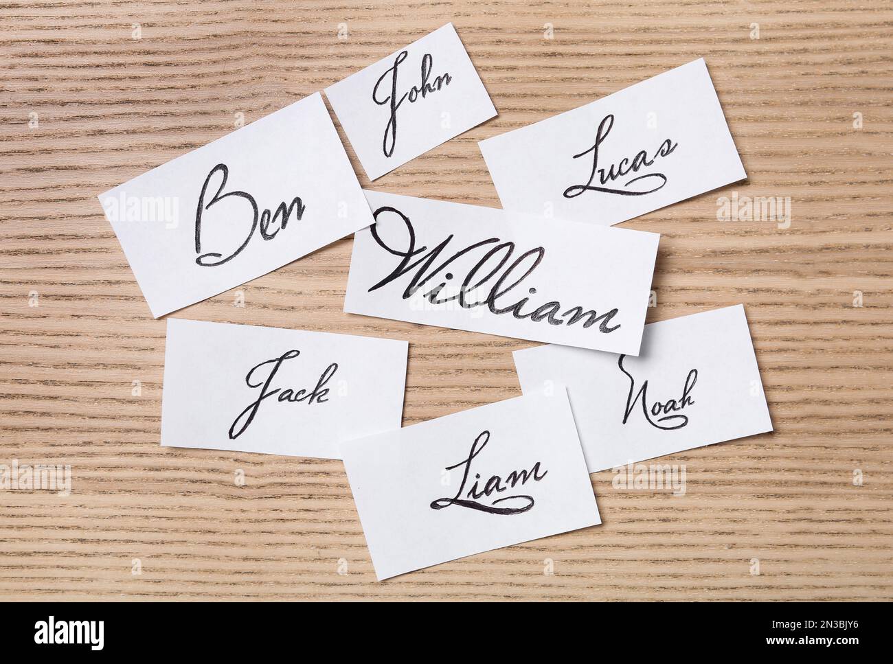 Paper sheets with written baby names on wooden table, flat lay Stock ...