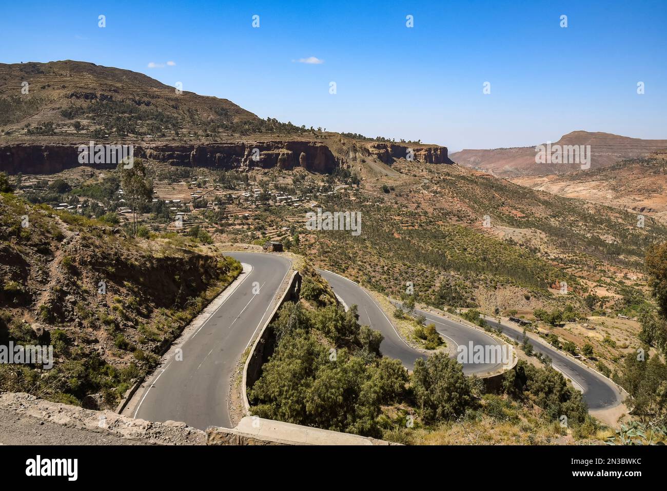 Winding paved road through the Ethiopian Highlands below a rural, mountain farming community in Northern Ethiopia; Ethiopia Stock Photo