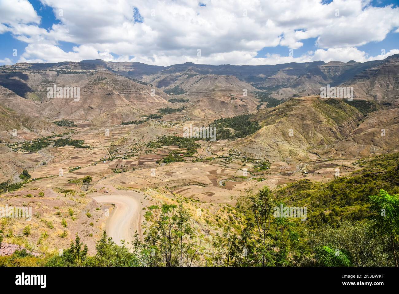 Dirt road through the Ethiopian Highlands with a rural, mountain farming village in Northern Ethiopia; Ethiopia Stock Photo
