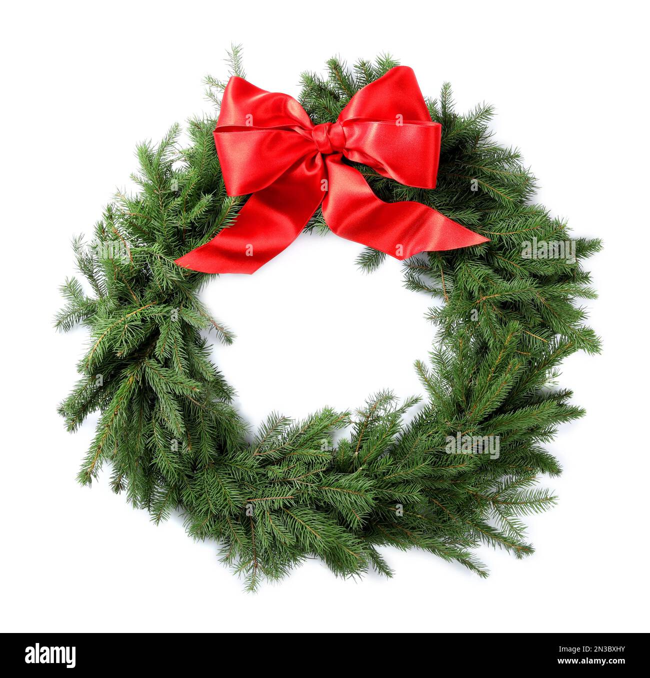 Christmas wreath made of fir branches with red bow on white background ...