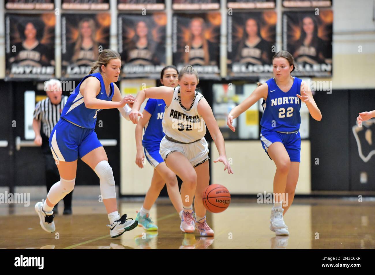 USA. Player driving on the basket with a trio of defenders in pursuit during a high school varsity basketball game. Stock Photo