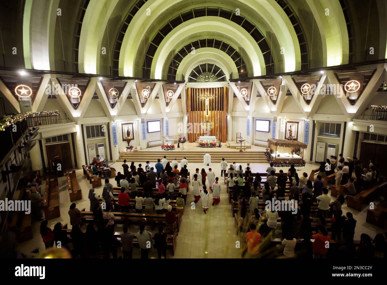 Filipino Catholics attend a dawn mass Tuesday, Dec. 16, 2014 to start a ...