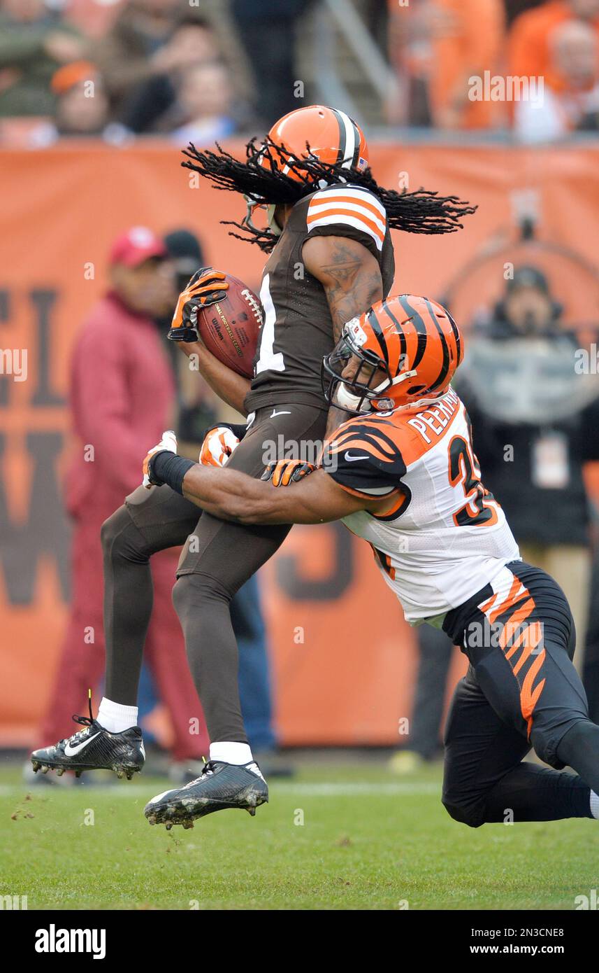 Cleveland Browns' Travis Benjamin is tackled by Cincinnati Bengals' Cedric  Peerman on a kick return in the second quarter of an NFL football game  Sunday, Dec. 14, 2014, in Cleveland. (AP Photo/David