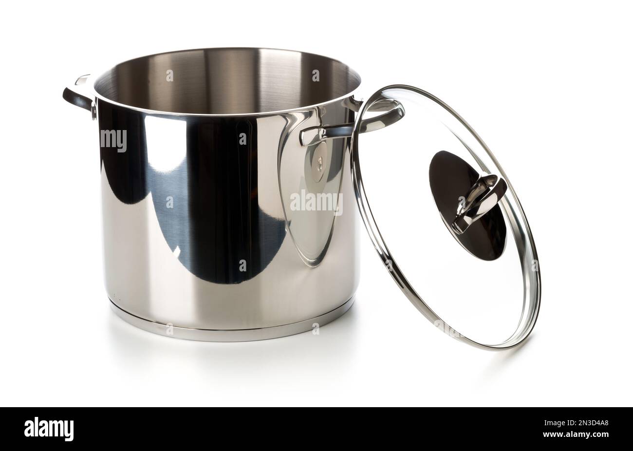 Large stainless steel cooking pot elevated view with glass lid leaning on the right side over white background Stock Photo