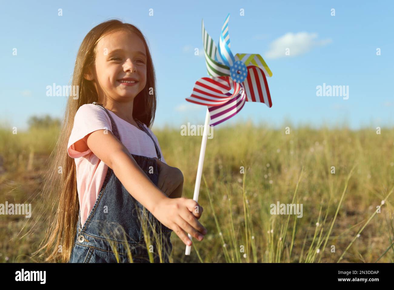 Cute little girl with pinwheel outdoors. Child spending time in nature ...