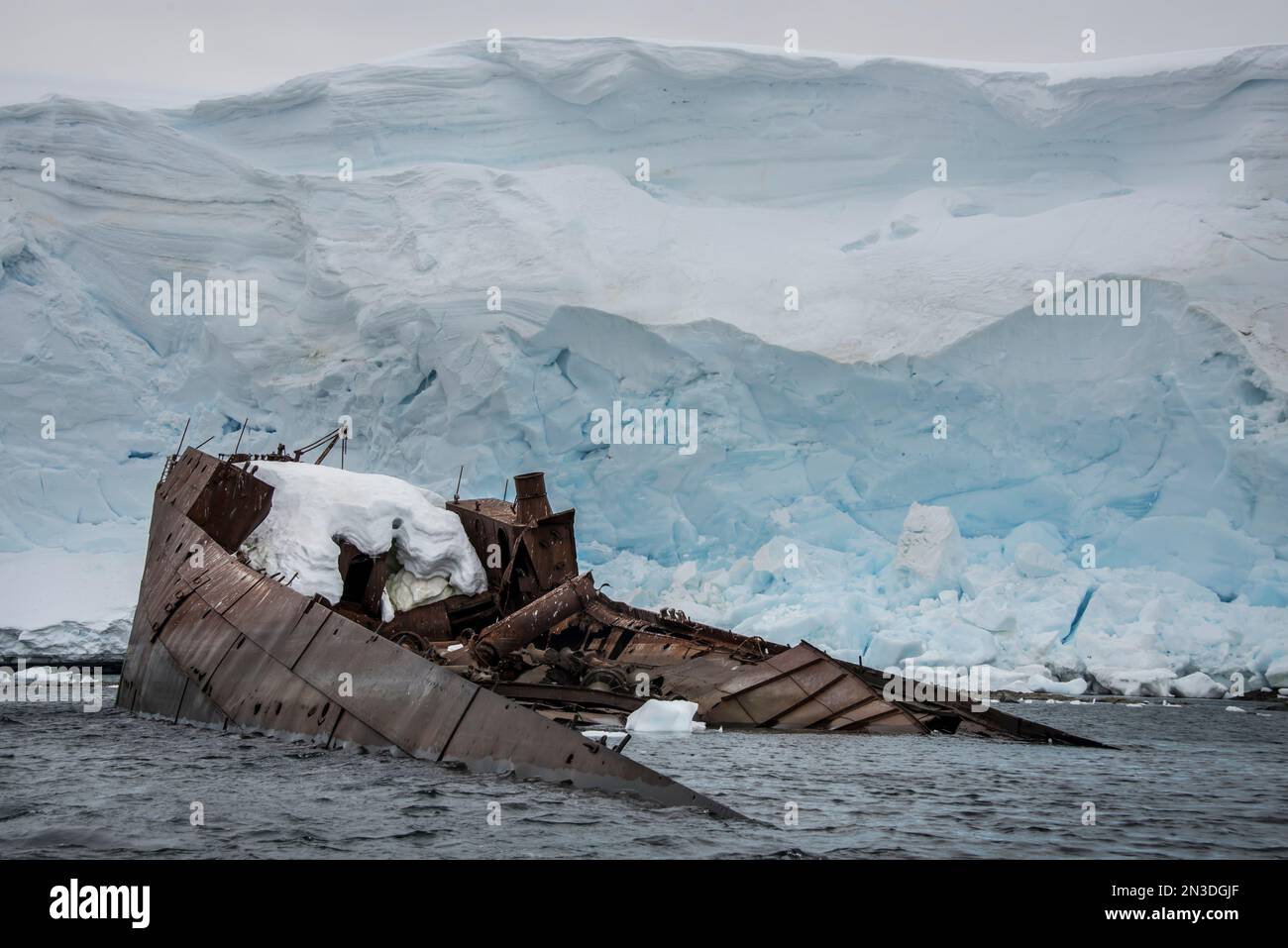 Wreckage of a century old whaling ship in the water along the shore at ...