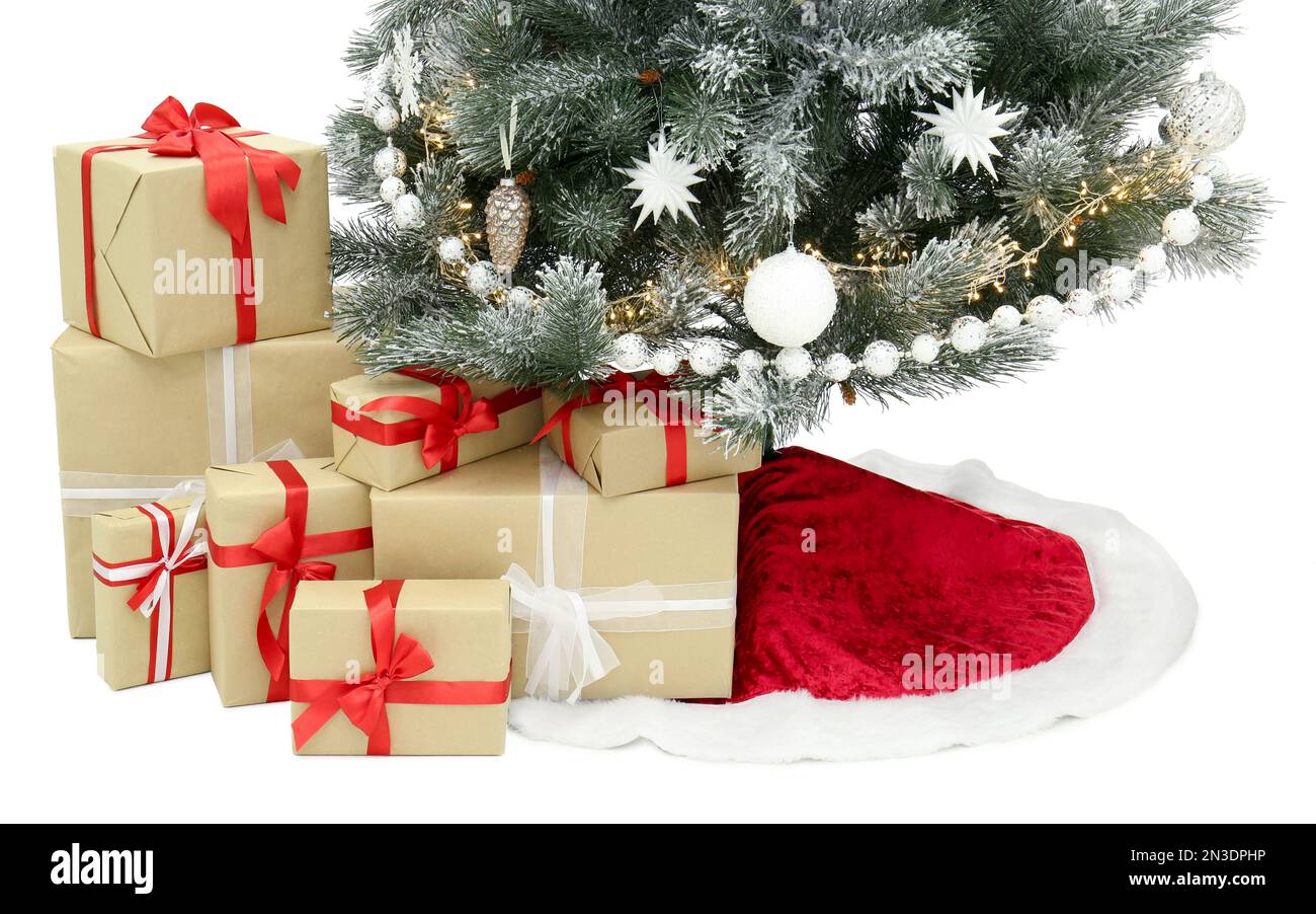 Decorated Christmas tree with red skirt and gift boxes on white ...