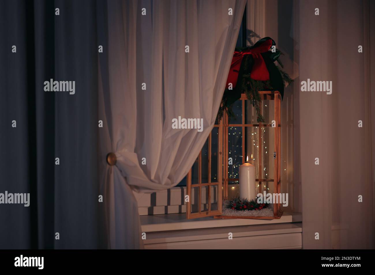 Beautiful Christmas lantern with candle on window sill indoors Stock