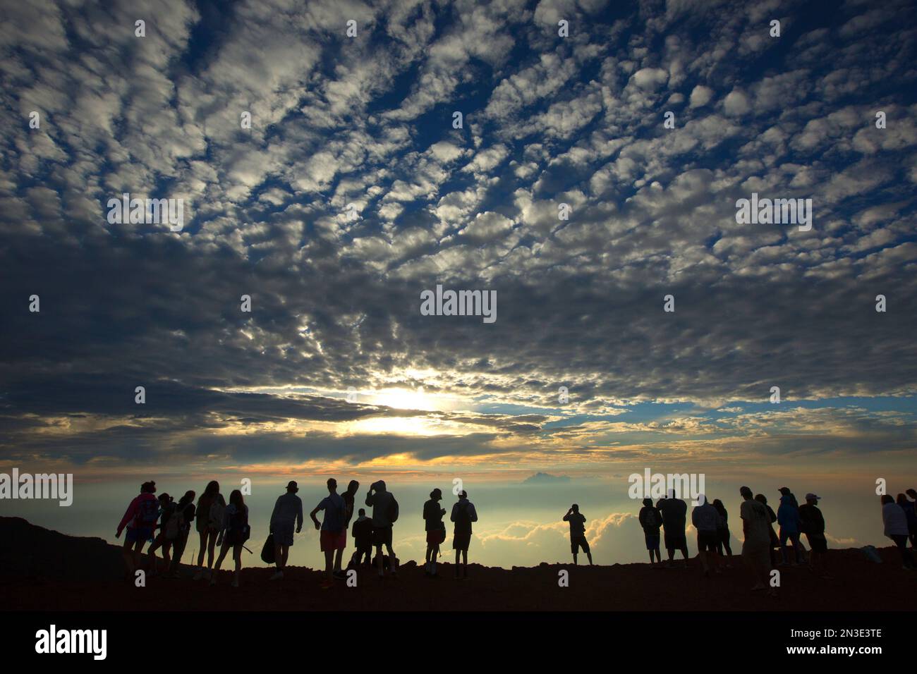 Silhouette of people watching the sunset from the top of Haleakala in Haleakala National Park; Maui, Hawaii, United States of America Stock Photo