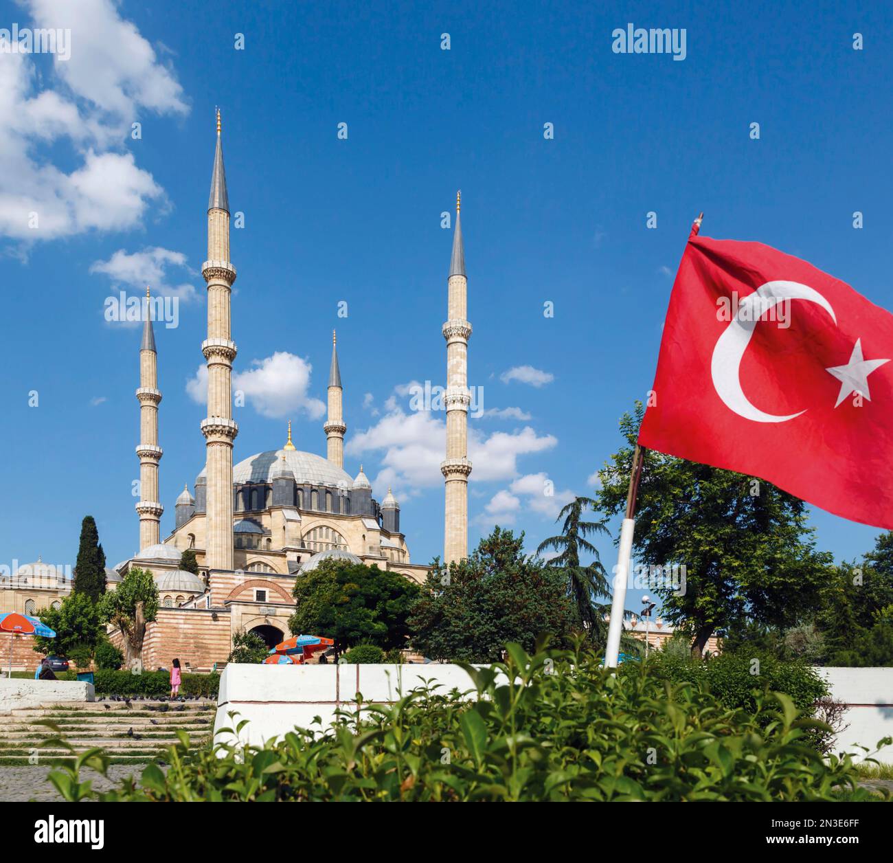 The 16th century Selimiye Mosque by architect Mimar Sinan, against a blue sky with the Turkish national flag flying; Edirne, Edirne Province, Turkey Stock Photo