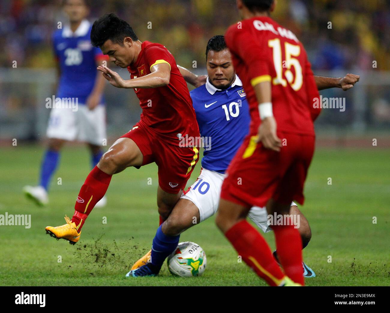 Vietnam's Ngo Hoang Thinh, left, and Malaysia's Mohd Safee Mohd Sali, center, battle for the ball during their semi final first leg soccer match of the AFF Suzuki Cup 2014 at a stadium in Shah Alam, outside Kuala Lumpur, Malaysia, Sunday, Dec. 7, 2014. (AP Photo/Lai Seng Sin) Stock Photo
