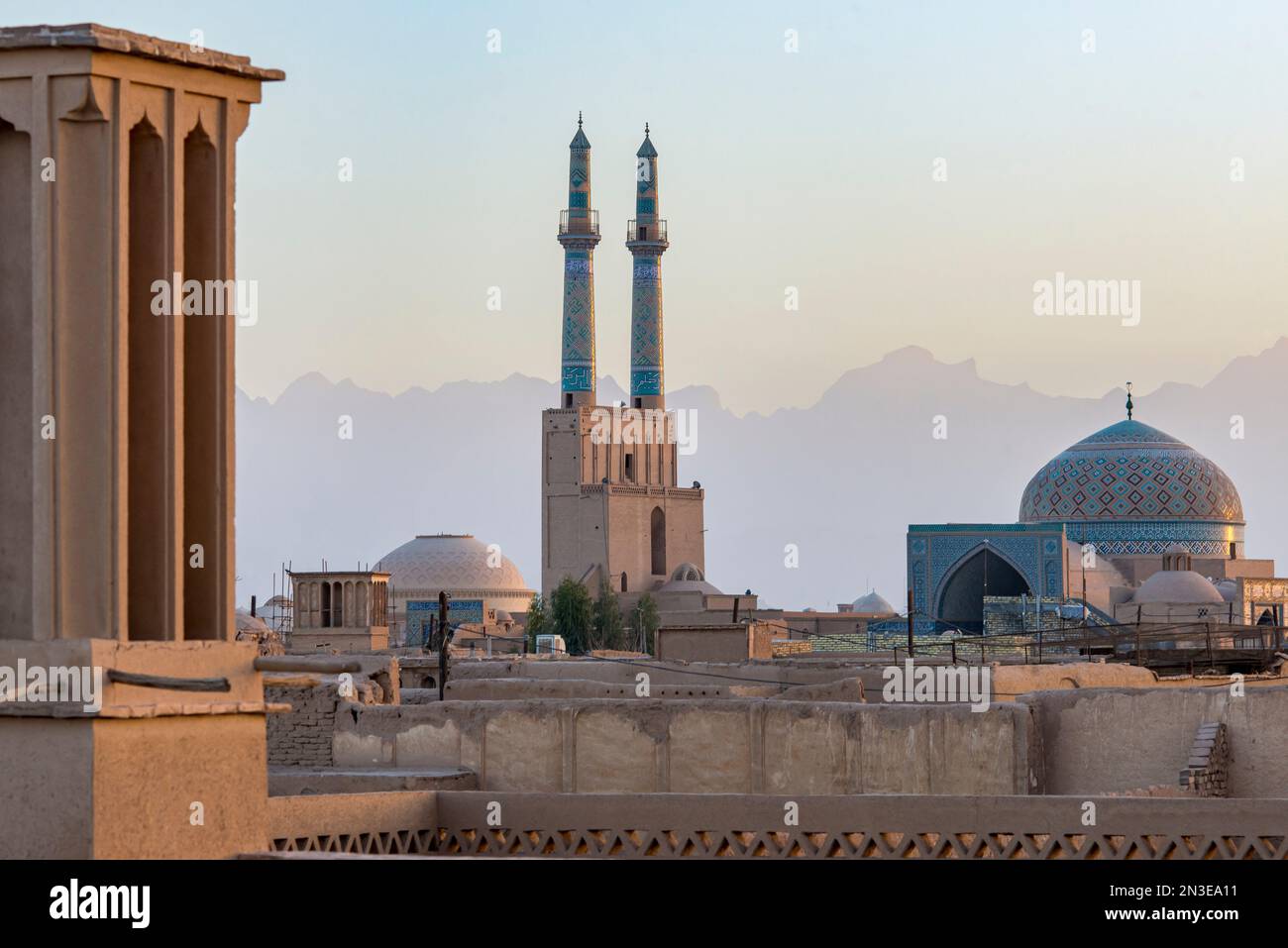 Overview of Jamesh Mosque of Yazd at sunset with the soft silhouette of the Zagros Mountain in the distance; Yazd City, Yazd Province, Iran Stock Photo