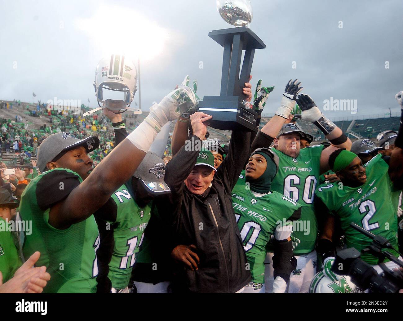 Marshall University head football coach Doc Holliday, holds up CUSA